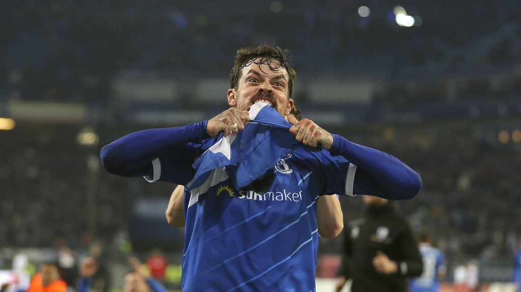 Ein Foto für die Ewigkeit: Dennis Erdmann vom 1. FC Magdeburg zerkaut nach dem Last-Minute-Sie beim Hamburger SV eine Eckfahne mit HSV-Logo.