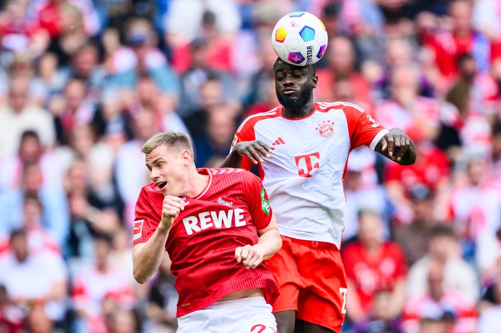 Bayerns Dayot Upamecano (r) im Zweikampf mit Kölns Steffen Tigges.