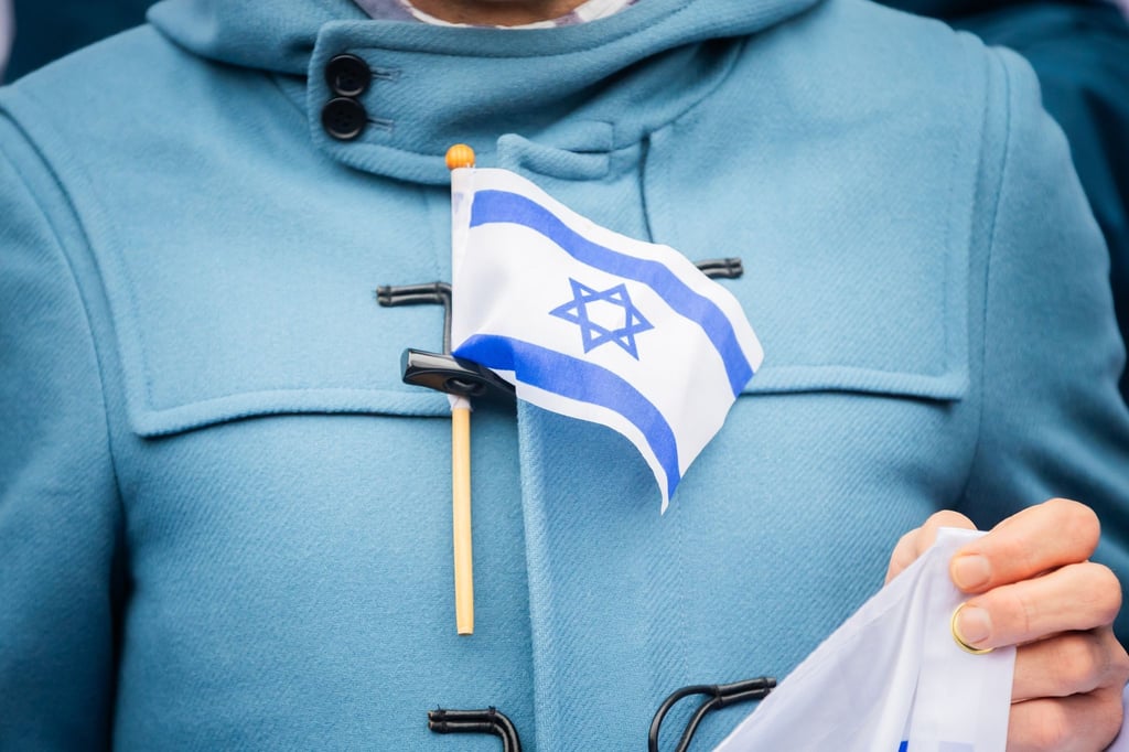 Eine Israel-Flagge steckt bei einem stillen Protest einer Initiative für die Sicherheit jüdischer Studierender an der Freien Universität Berlin an der Jacke eines Teilnehmers.