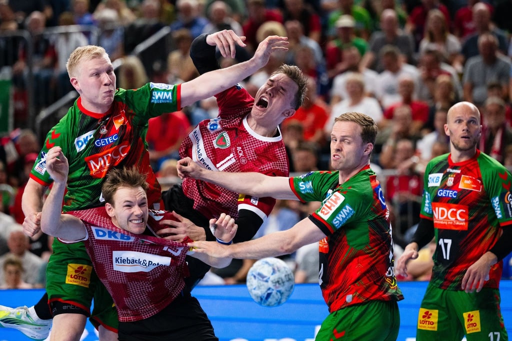 Magdeburgs Magnus Saugstrup (l) und Omar Ingi Magnusson (2. v.r.) kämpfen mit Berlins Mathias Gidsel (2. v.l.) und Lasse Andersson (M) um den Ball.