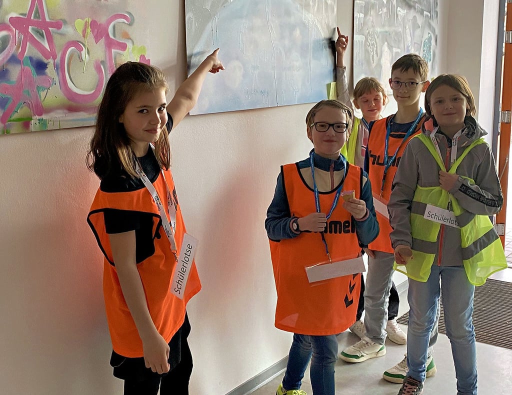Die Schülerlotsen Lotti (von links), Finja ,Romy, Konstantin und Mila zeigen den Besuchern der Welslebener Schule das Graffiti-Projekt.