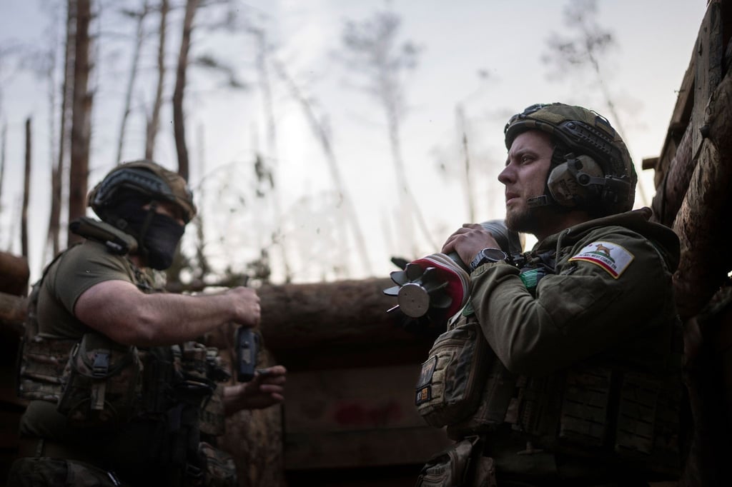 Ein ukrainischer Soldat trägt eine Mörsergranate, während er auf einen Feuerbefehl wartet.