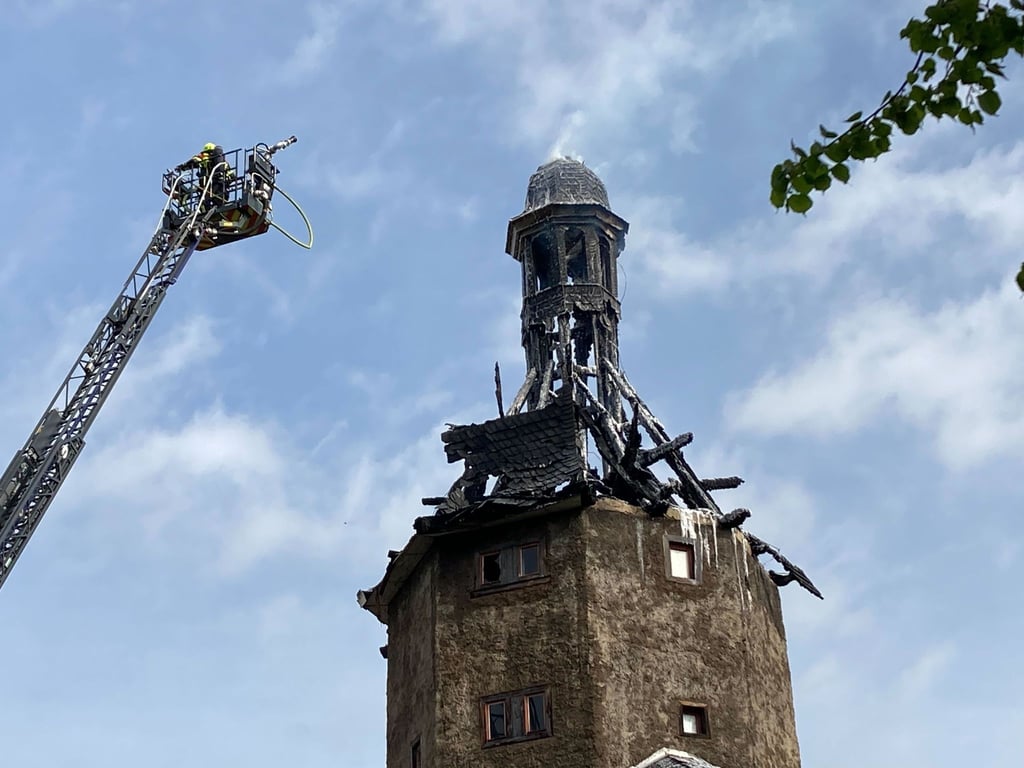 Feuerwehrkräfte sind an der Spitze vom historischen Neutorturm in Arnstadt auf einer Leiter zu sehen.