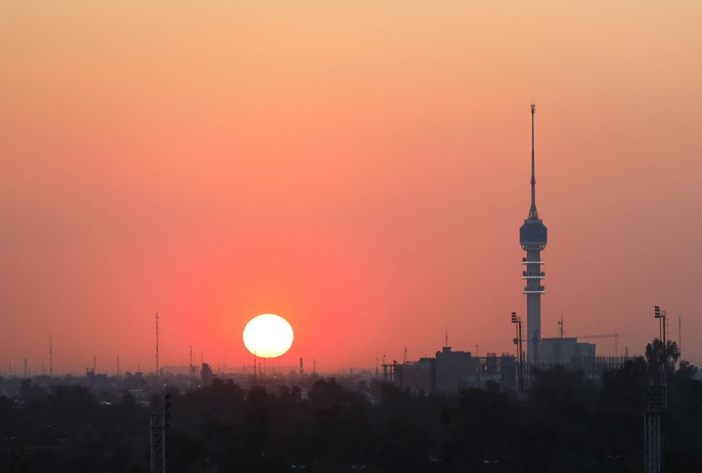 Die Sonne geht hinter der Skyline von Bagdad unter.