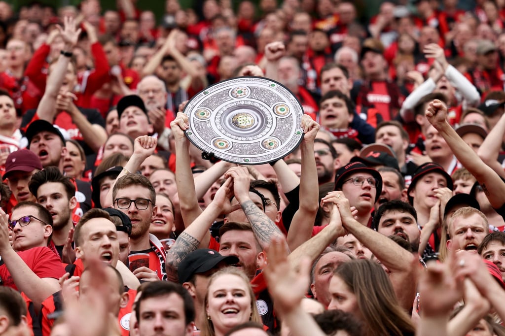 Fußball: Ein Leverkusener Fan hält während des Spiels eine Nachbildung der Meisterschale in den Händen. Bayer Leverkusen gewinnt die Deutsche Meisterschaft.