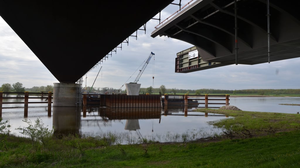 Tonnen von Stahl hängen auf Wittenberge-Seite in der Luft. Beim nächsten „Verschub“ soll die A14-Brücke den ersten Strompfeiler erreichen. Links die B189-Brücke mit ovalen Pfeilern. 