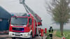 Einsatzkräfte der Feuerwehr versuchen in der Altmark im dichten Rauch den Brand in der einer Schweinemastanlage zu löschen.