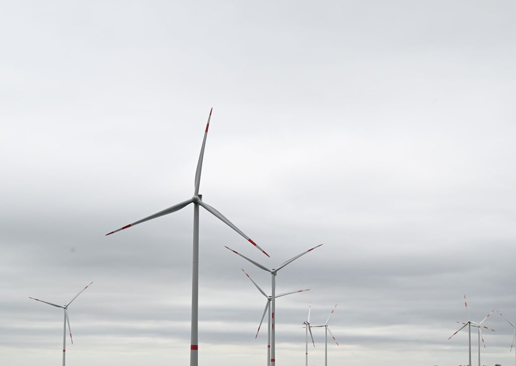 Bei starkem Wind und wolkenverhangenem Himmel drehen sich Windräder zur Stromerzeugung.