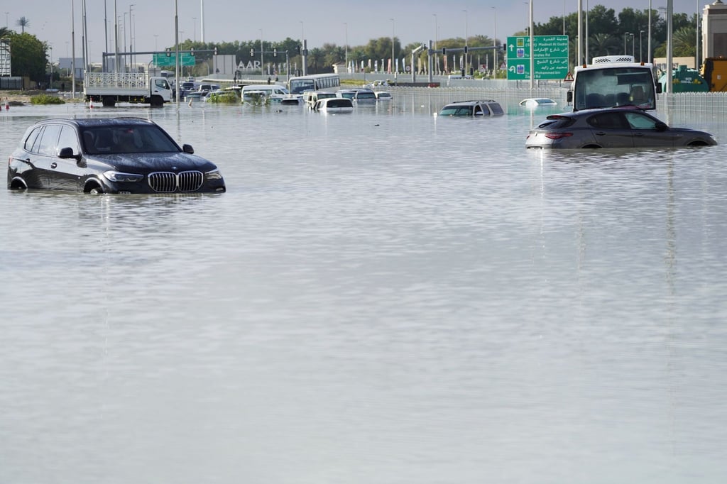 Fahrzeuge stehen verlassen im Hochwasser auf einer Hauptstraße in Dubai.