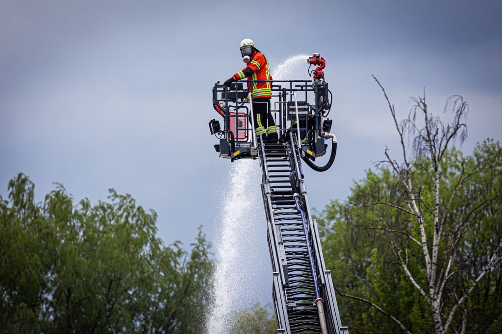 Einsatzkräfte der Feuerwehr löschen über eine Drehleiter einen Brand in einem Braunschweiger Industriegebiet.