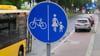 Ein Schild für einen getrennten Rad- und Gehweg steht vor einer Zone, in der das Parken auf halbem Gehweg erlaubt ist.