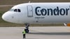 Der Pilot einer Condor-Maschine mit Ziel Teneriffa winkt dem Bodenpersonal vor dem Start vom Flughafen Leipzig/Halle.