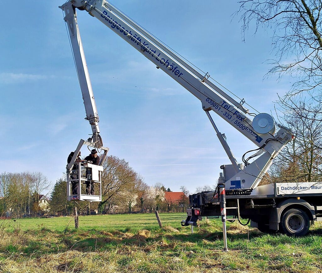 Mit dem Hubsteiger wird das alte Nest am Dorfteich in Berenbrock entfernt und die neue Nestunterlage auf den Mast gebracht.
