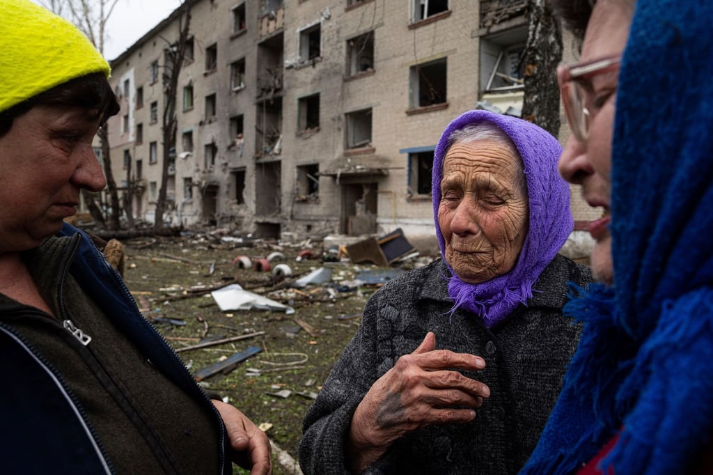 Frauen stehen in Lukiantsi in der Region Charkiw vor einem Haus, das durch einen russischen Luftangriff schwer beschädigt wurde.
