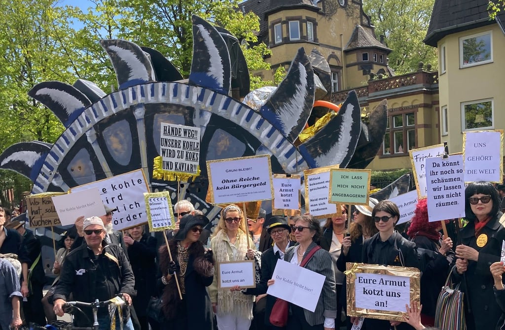 Teilnehmer der linken Demonstration „MyGruni“ stehen 2023 mit Plakaten im Villenviertel Berlin-Grunewald.