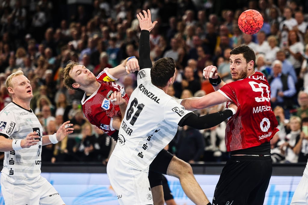 Spieler des THW Kiel und der Füchse Berlin kämpfen um den Ball.