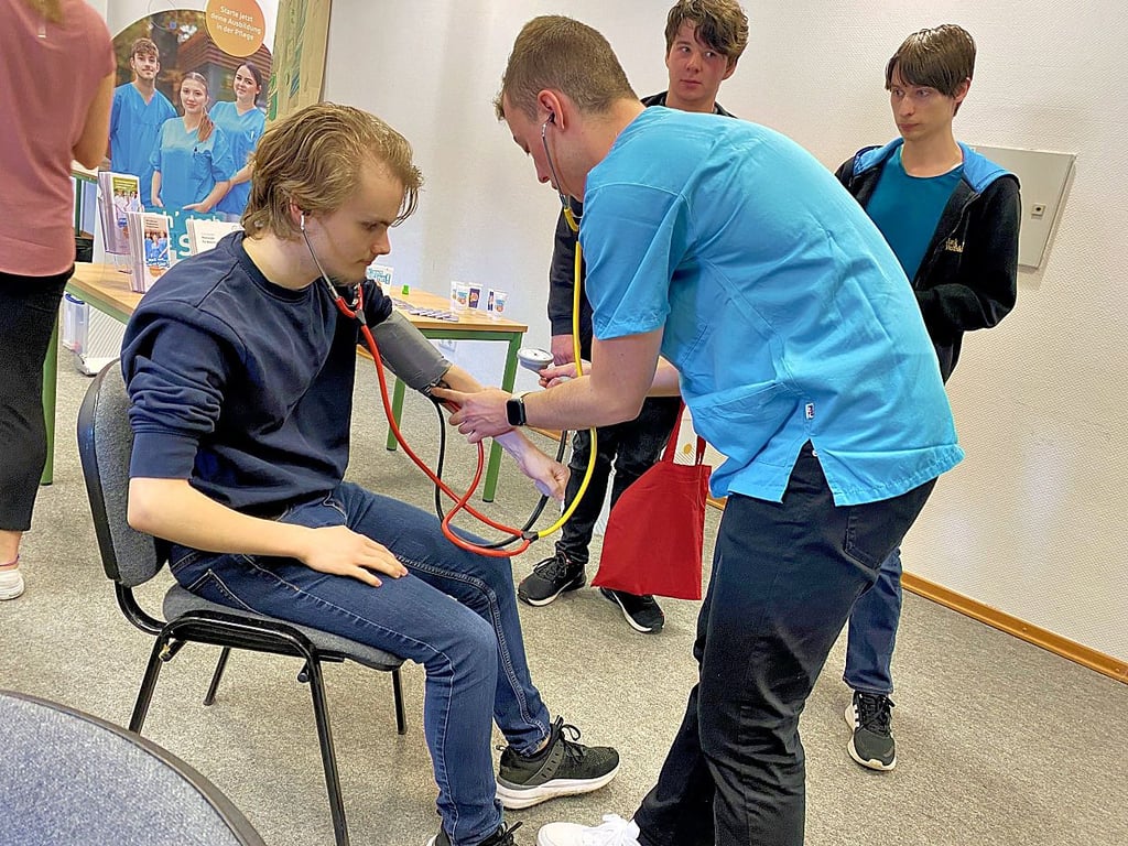 Willi Böhme (rechts) ist Auszubildender im Salus-Fachklinikum in Uchtspringe. Beim Tag der Pflege im Berufsschulzentrum Stendal zeigte er den Besuchern Aufgaben aus seinem Arbeitsalltag. Dazu gehört das Blutdruckmessen bei Patienten.