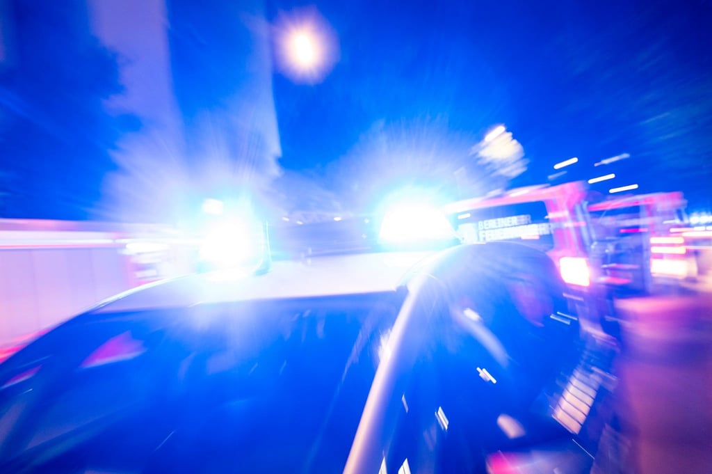 Ein Streifenwagen der Polizei steht mit Blaulicht an einem Einsatzort.