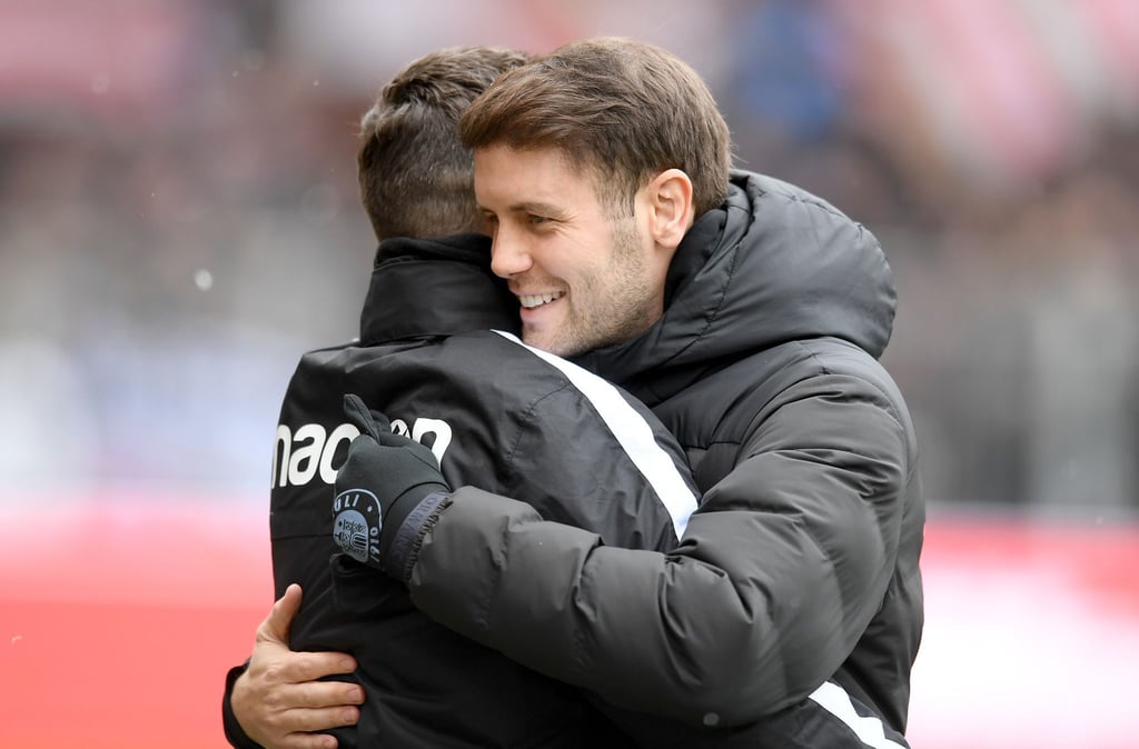 St. Paulis Trainer Fabian Hürzeler (r) wird von Hannovers Trainer Stefan Leitl begrüßt.