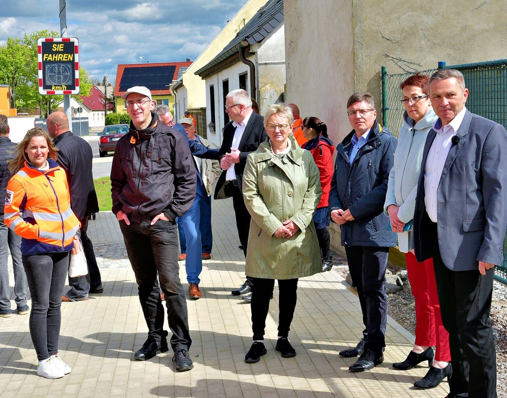 Projektleiter Uwe Reh (rechts) und Solvay-Werkleiter Hugo Walravens (3. von rechts) erläutern Nienburgs Bürgermeisterin Susan Falke (2. von rechts), Bernburgs Oberbürgermeisterin Silvia Ristow (4. von rechts) sowie zahlreichen Gästen das fertiggestellte Straßenbauprojekt.