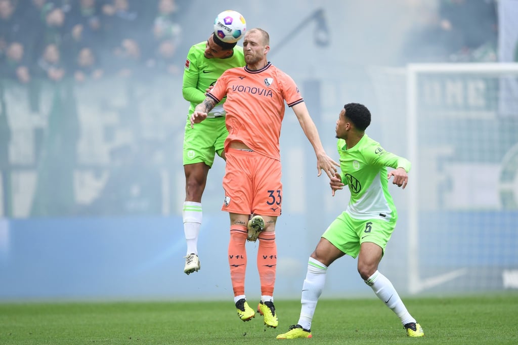 Wolfsburgs Maxence Lacroix (l) spielt gegen Bochums Philipp Hofmann.