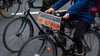 Bei einer Demo fährt ein Fahrradfahrer mit einem Schild mit der Aufschrift „„Fahrradfahr’n“ statt Autobahn“.