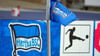 Die Eckfahne steht vor dem Logo der Bundesliga und des Vereins.