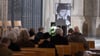 Teilnehmer eines Gedenkgottesdientes für den verstorbenen Komponisten Udo Zimmermann sitzen in der Kreuzkirche.