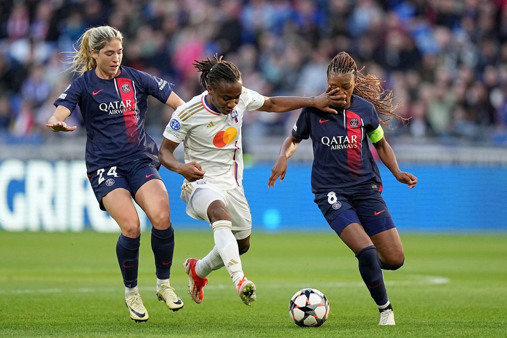 Korbin Albert (l) und Grace Geyoro von PSG versuchen Lyons Melchie Dumornay (M) vom Ball zu trennen.