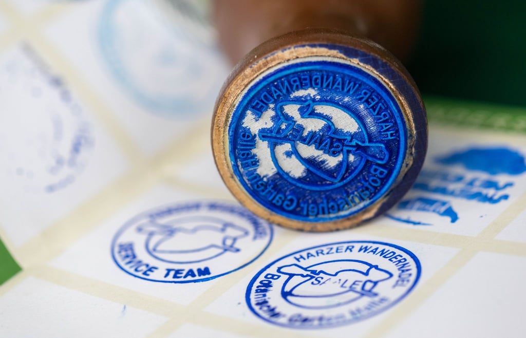 Der neue Stempel der Harzer Wandernadel ist vor einem Wanderpass zu sehen.