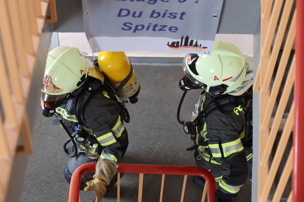 Feuerwehrmänner mit Atemschutzmaske und Sauerstoffflasche rennen eine Treppe hoch beim 10. Zwickauer Hochhaus-Treppenlauf und 5. Feuerwehr-Treppenlauf.