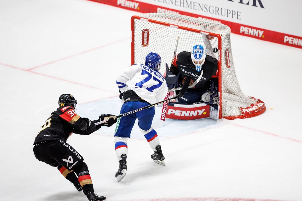 Slowakeis Martin Fasko-Rudas (M) trifft zum 4:5. DEB-Torhüter Florian Bugl (r) kann den Puck nicht abwehren.