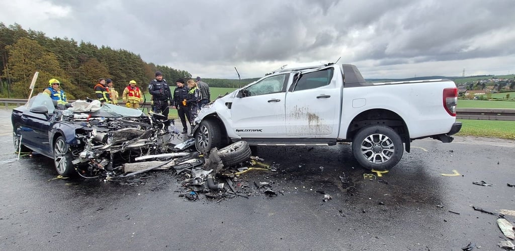 Zwei Autos stehen nach einem Unfall auf der Fahrbahn.