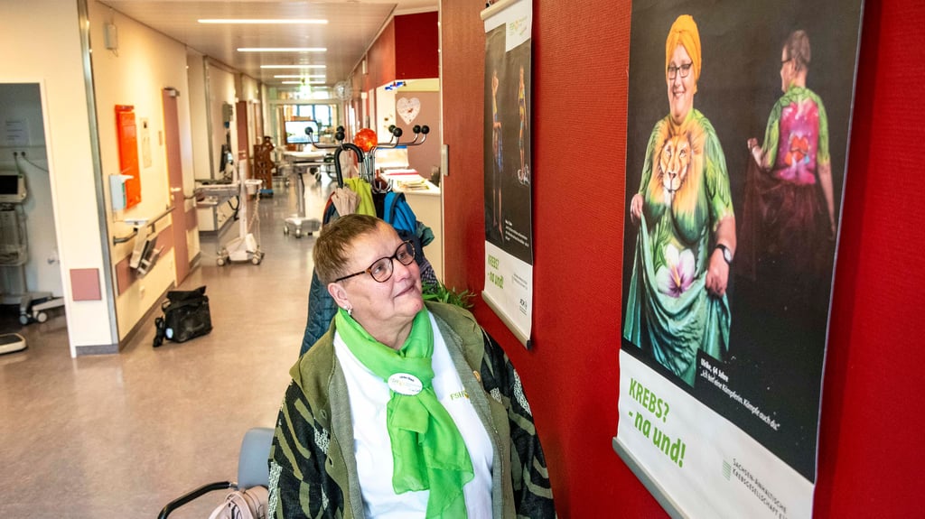 Ulrike Strach betrachtet ihr Bild in der Ausstellung "Krebs? Na und!" auf Station 6 im Klinikum.