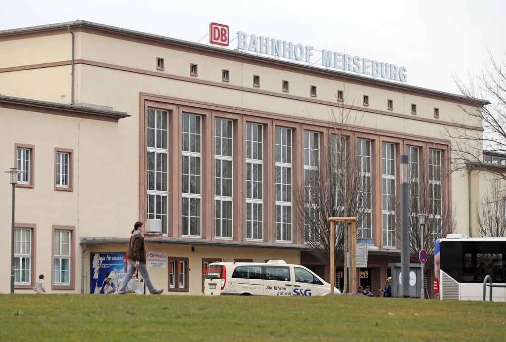 Eine Frau geht über den Bahnhofsvorplatz von Merseburg (Sachsen-Anhalt).