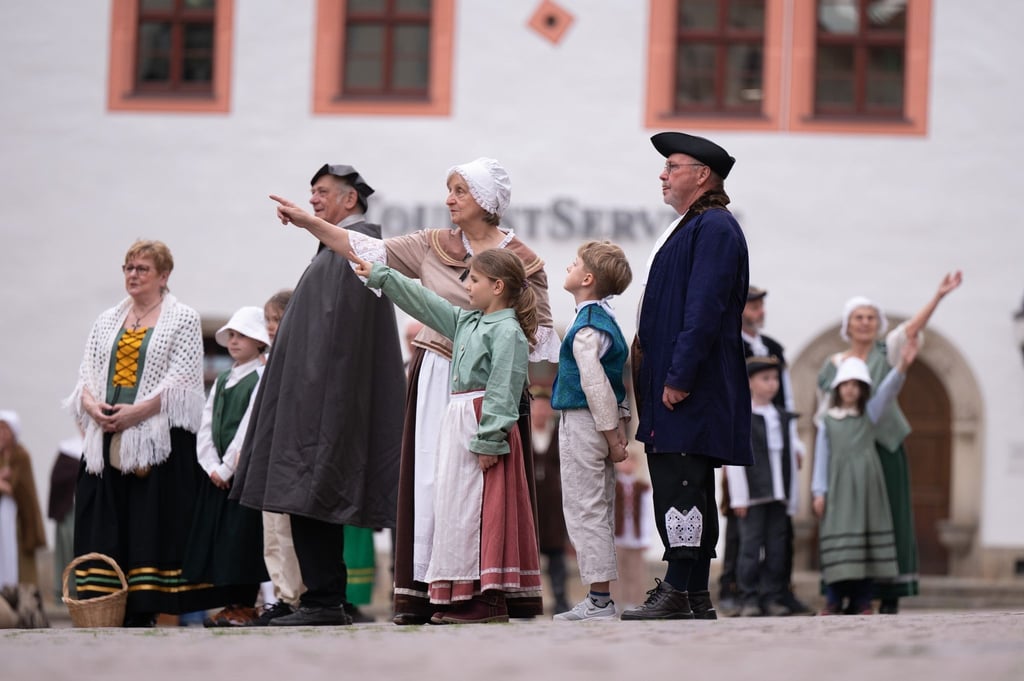 Laiendarsteller stehen während der Nachstellung des Gemäldes „Der Marktplatz zu Pirna“ von Bernardo Bellotto auf dem Marktplatz.
