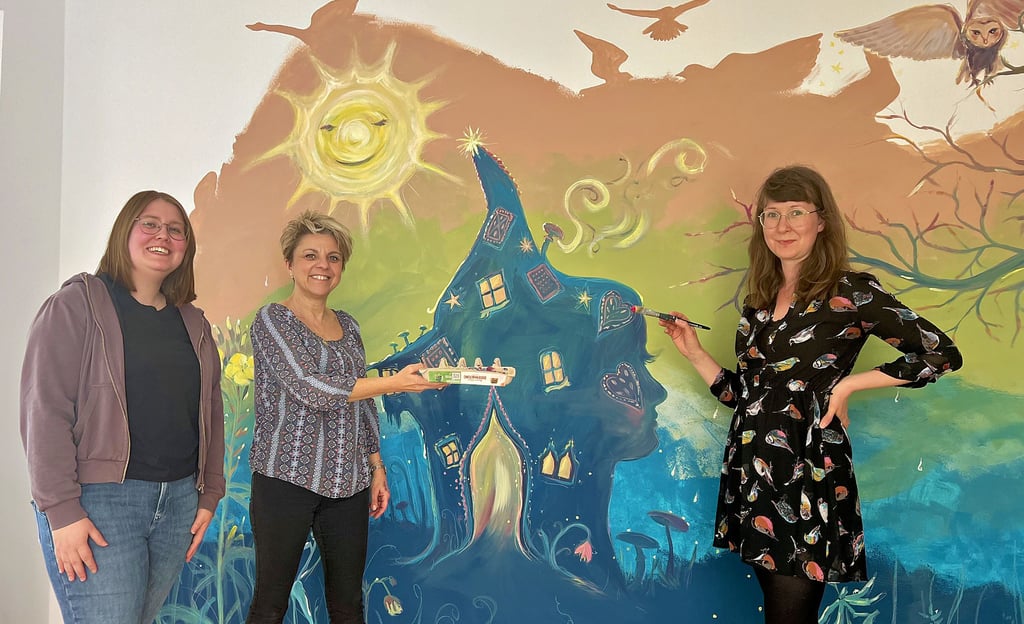 Sabine Marschewski (rechts) hat in der Dedelebener Kita-Bibliothek ein Wandbild gestaltet – zur Freude der Kinder und von Leiterin Manuela Fischer (Mitte) und Sprachfachkraft Melanie Fleck.