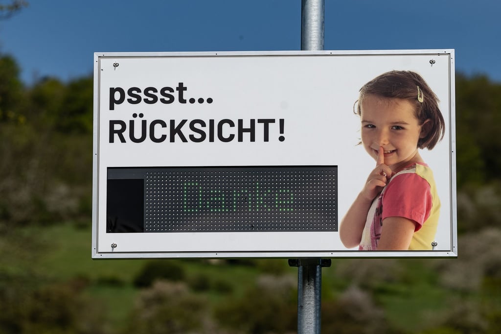 Ein Lärmdisplay mit der Aufschrift „pssst... Rücksicht!. Danke“ steht an einem Ortseingang.