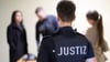 Justizbeamte führen vor dem Prozess nach dem tödlichen Unfall auf der Bobbahn in Oberhof Sicherheitsvorkehrungen am Amtsgericht in Suhl durch.