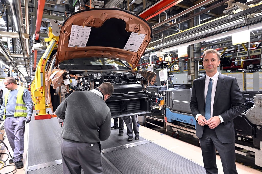 Florian Huettl, Geschäftsführer der Opel Automobile GmbH, steht neben einem Opel Grandland electric.