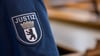 Ein Abzeichen mit dem Wort „Justiz“ und dem Landeswappen von Berlin ist an der Uniform eines Justizvollzugsbeamten im Kriminalgericht Moabit angebracht.