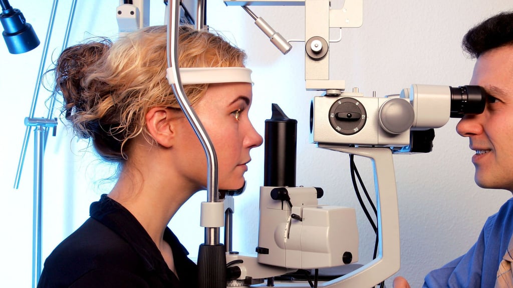 Ein Augenarzt untersucht mit einer Spaltlampe die Augen einer Patientin. In der Börde ist das nur mit langen Wartezeiten verbunden.