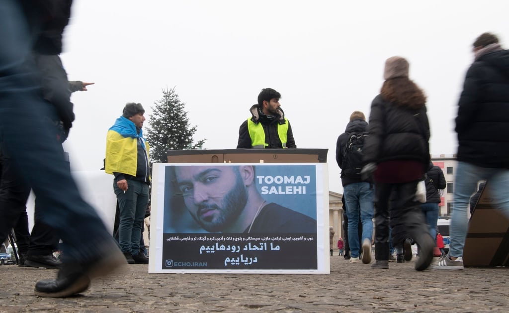 Protestaktion gegen Irans Staatsführung auf dem Pariser Platz in Berlin. Auf dem Plakat ist der Rapper Salehi zu sehen.