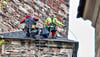 Eisleben: Die Industriekletterer haben sich von oben aus der sogenannten Laterne abgeseilt und reparieren Schäden an den Schieferdächern der St.-Andreas-Kirche.