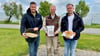 Wenn regionale Unternehmen zusammenhalten: Rackither Agrarchef Tino Gast (v. l.), Jürgen Boeltzig von der Neumühle Skassa und Bäckermeister Alexander Dorn zeigen symbolisch den Weg vom Korn zum Brötchen.