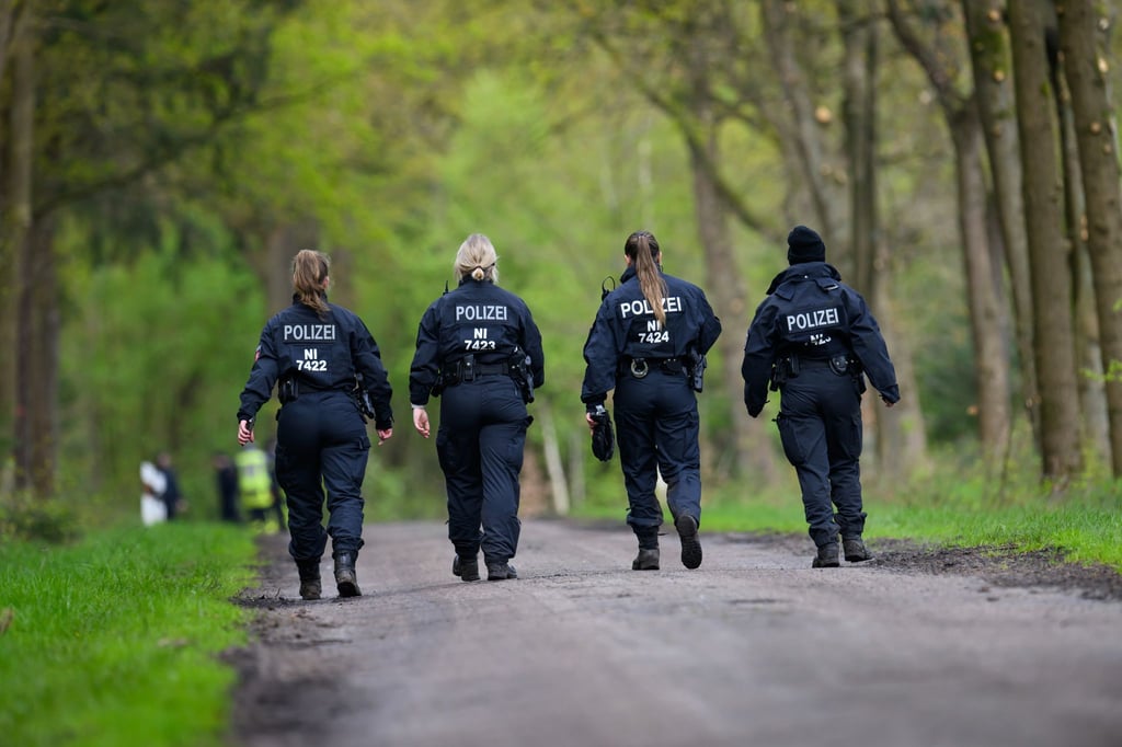 Einsatzkräfte der Polizei sind in einem Waldstück im Einsatz.