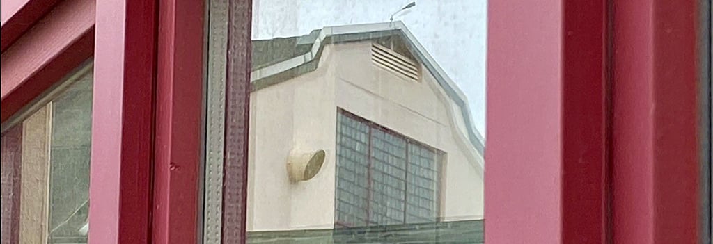 Die Hermann-Gieseler-Halle spiegelt sich in einer Fensterscheibe.
