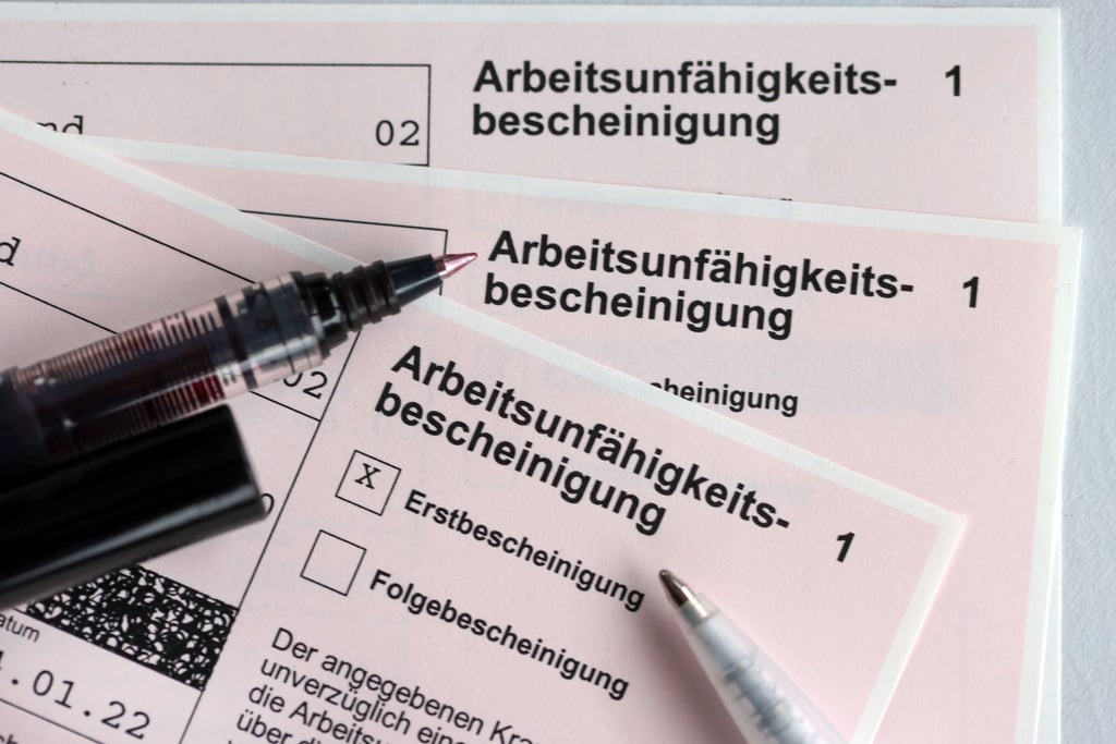 Mehrere Arbeitsunfähigkeitsbescheinigungen liegen auf einem Tisch.