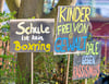 „Schule ist kein Boxring“ und „Kinder frei von Gewalt“ steht auf Schildern während einer Demonstration am 19. März 2024 vor dem Schulamt Cottbus.
