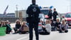 Ein Polizist beobachtet Klimaaktivisten auf der Dresdner Carolabrücke.